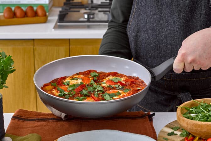 Man holdng large frying pan full of food