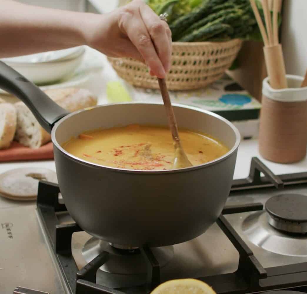 Stirring soup in large saucepan